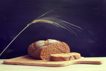 healthy product for a healthy lifestyle/  sliced, traditional bread, lays on a wooden board, on a dark background  © zoomingfoto1712