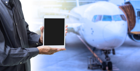 Businessman hands holding digital tablet computer with blur airplane background