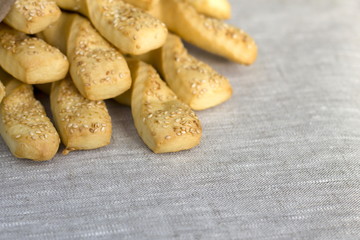 Fresh baked grissini bread sticks on linen tablecloth.