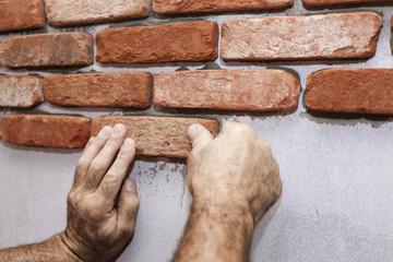 Wall facing work with brick by professional bricklayer worker