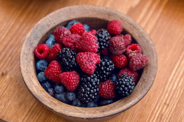 fresh berries , strawberries, raspberries, blueberries in a copper bowl