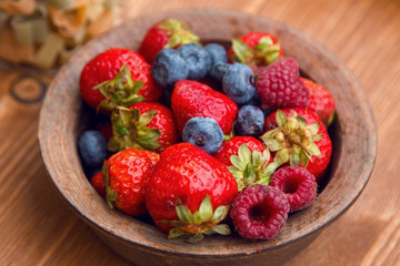 fresh berries , strawberries, raspberries, blueberries in a copper bowl