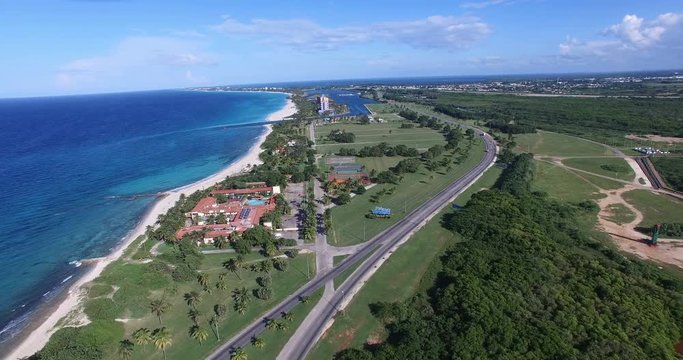Drone moves down to an inscription Varadero. Bird's-eye view above tropical island and the bay of calm Atlantic Ocean.