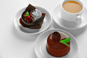 Chocolate cake with fresh currant and tea on light background