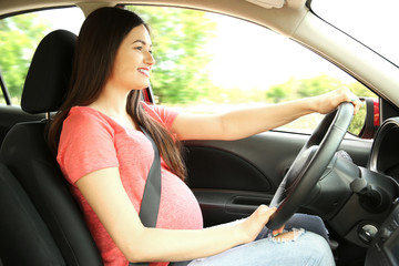 Fototapeta na wymiar Pregnant woman driving car. Safety drive concept