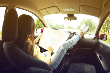 Woman sitting with road map in car