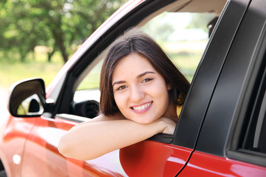 Young beautiful woman in red car