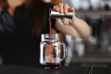 Woman hands making cocktail on bar counter
