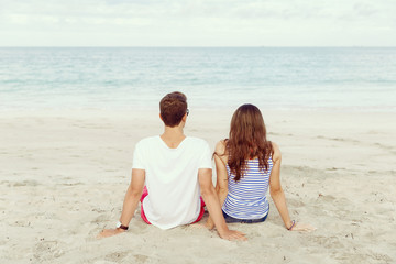 Romantic young couple sitting on the beach