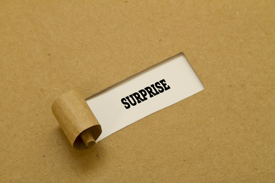 SURPRISE word written under torn paper.