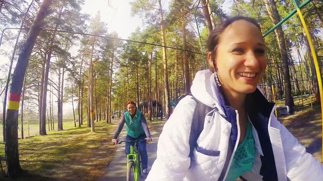 Happy friends riding bicycles in a park on sunny day in slowmotion. 1920x1080