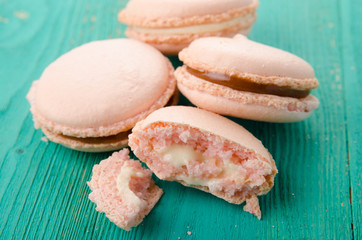 Sweet and colourful french macaroons on wood turquoise background