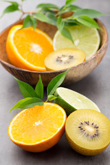 Mixed citrus fruit lemons, orange, kiwi, limes on a gray backgro