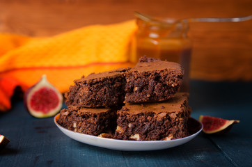 Brownie with walnuts, figs on a dark blue background with a yellow cloth