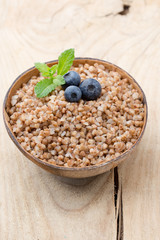 Buckwheat porridge in a bowl with mint leaves and blueberries.