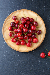 Fresh cherries on wooden plate top view