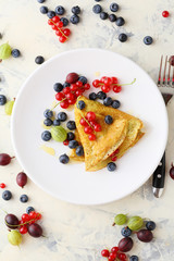 Summer crepe with berries on white plate