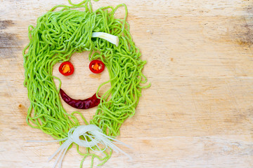 smile faces on wood background made from vegetable and noodle wi