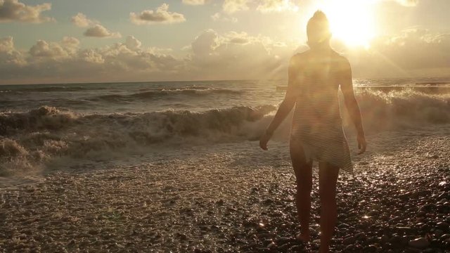 girl undresses at the sea. silhouette of a beautiful woman.