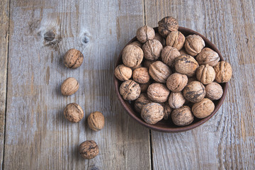 walnuts in a clay plate on a wooden background. top view