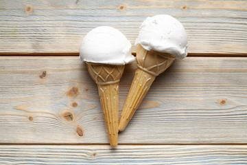 Fototapeta na wymiar Ice cream in the cone on wooden board