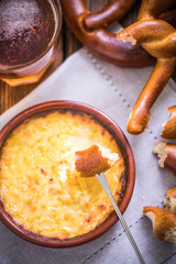 worming cheese fondue with pretzel at winter