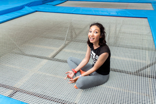 Attractive Young Woman Sat On A big Trampoline