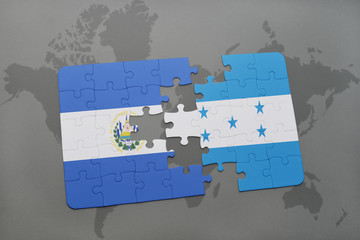 Fototapeta premium puzzle with the national flag of el salvador and honduras on a world map background.