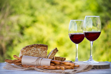 Wine, bread and wheat on the wooden table