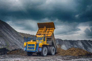 Obraz premium NOVOKUZNETSK, RUSSIA - JULY 26, 2016: Big yellow mining trucks and excavators at worksite 