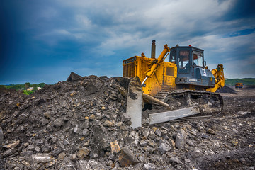 Obraz premium NOVOKUZNETSK, RUSSIA - JULY 26, 2016: Big yellow mining trucks and excavators at worksite 