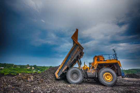 NOVOKUZNETSK, RUSSIA - JULY 26, 2016: Big yellow mining trucks and excavators at worksite
