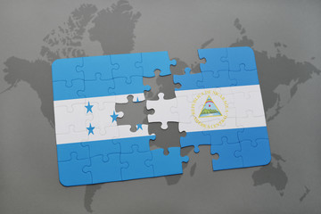 puzzle with the national flag of honduras and nicaragua on a world map background.