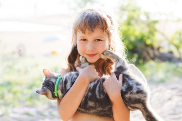 Happy child with cat outdoors.

