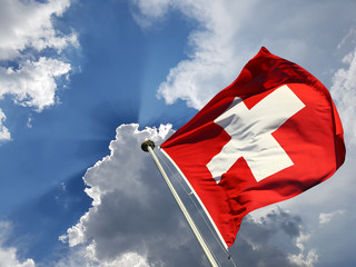 Switzerland national day background: Swiss flag against blue sky with white clouds and sun  rays...