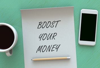 BOOST YOUR MONEY, message on paper, smart phone and coffee on table, 3D rendering