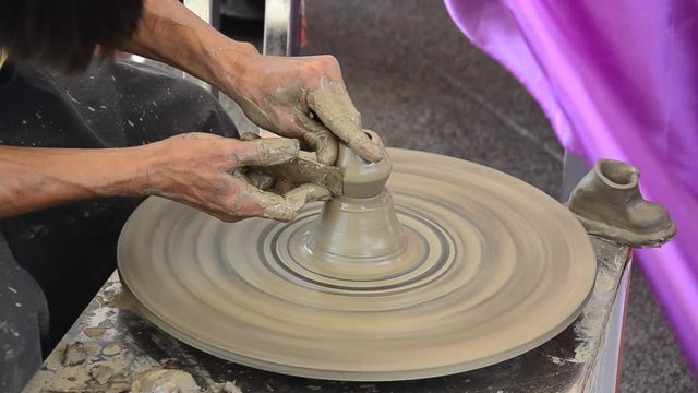 Professional thai old man using mechanic pottery made earthenware for show in traditional culture thai festival at Koh Kret Island in Nonthaburi Thailand.