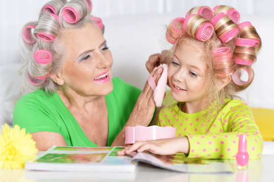 Senior woman and granddaughter doing make up