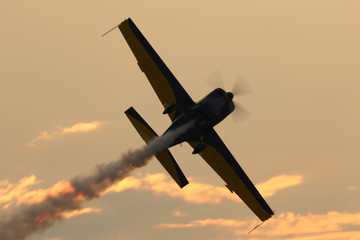 Silhouette of airplanes performing acrobatic flight at sundown.