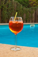 Cold summer drink by the pool. Party with refreshments by the pool. Alcohol drink with ice. Glasses with a refreshing drink. Alcohol at the party.
