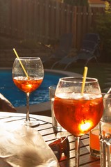Cold summer drink by the pool. Party with refreshments by the pool. Alcohol drink with ice. Glasses with a refreshing drink. Alcohol at the party.
