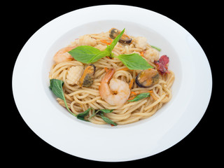 Spaghetti spicy with seafood on a white plate isolated on the black background with clipping path