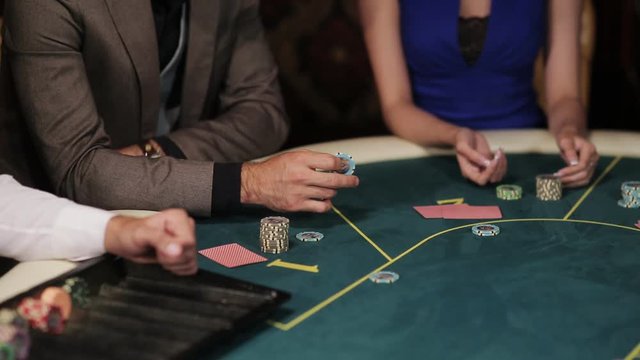 The company of players at the poker table. The dealer deals the players cards