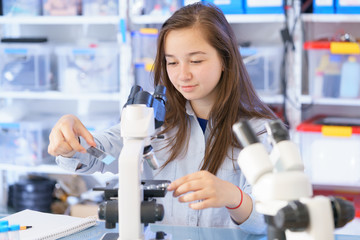 Female Teenage Student In Science Class With Experiment, Young Woman Student In Science Class With Microscope end Microscope slide - obrazy, fototapety, plakaty