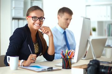 Fashion designers working in studio sitting on the desk