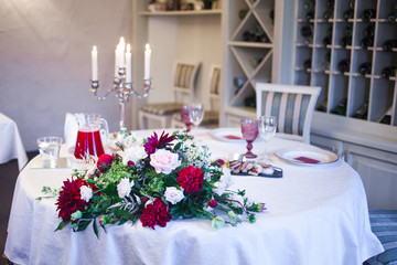 interior of the restaurant, large table laid for Banquet, decorated in Burgundy tones