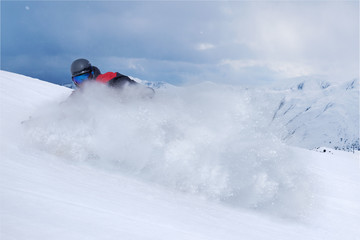 Naklejka na ściany i meble Snowboarder riding fast on dry snow freeride slope.