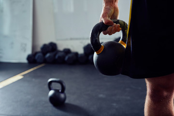 Closeup of kettlebell held by athlete at the gym
