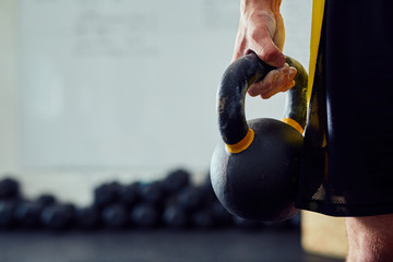 Closeup of kettlebell held by men at the gym