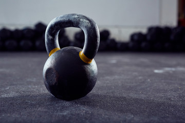 Naklejka na ściany i meble Closeup of kettlebell weight on gym floor
